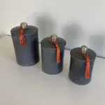 Gray round Moroccan handmade stucco jars with orange tassels