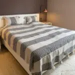 White Moroccan handwoven bedspread with black stripes and white pompoms