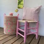 Moroccan handmade stool in pink, with pink cushion cover and pink basket next to it
