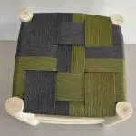 Moroccan handmade wooden stool with seat of braided cord in black and green pattern, from above