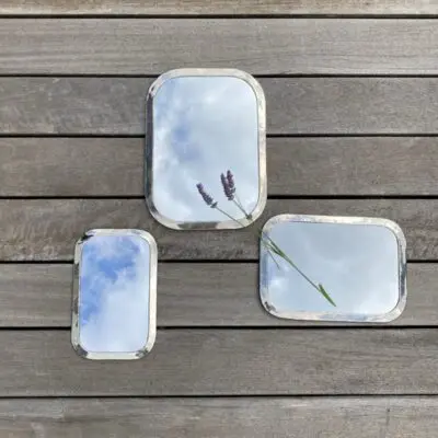 Three rectangular Moroccan handmade mirrors with rounded edges in silver metal in various variations, with floral decorations around