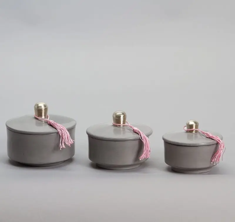 Gray round low Moroccan handmade stucco jars with pink tassels