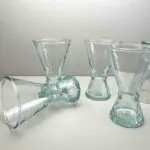 Handmade transparent beldi wine glasses, one of them lying down on a table