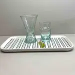 Handmade transparent bledi glasses and wine glasses standing on top of a dish, with a lime in front