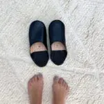 Moroccan handmade slippers in black with foot model on the side
