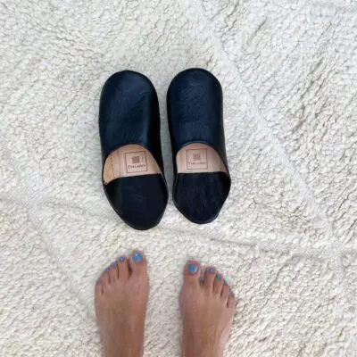 Marokkaanse handgemaakte pantoffels in zwart met voetmodel aan de zijkant