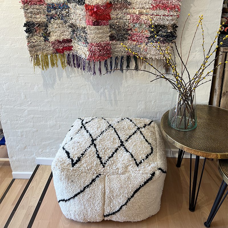 Firkantet marokkansk håndsyet gulvpude i uld med sort diamantmønster, stående i stue