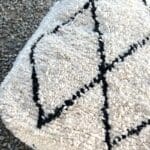 Firkantet marokkansk håndsyet gulvpude i uld med sort diamantmønster, tæt