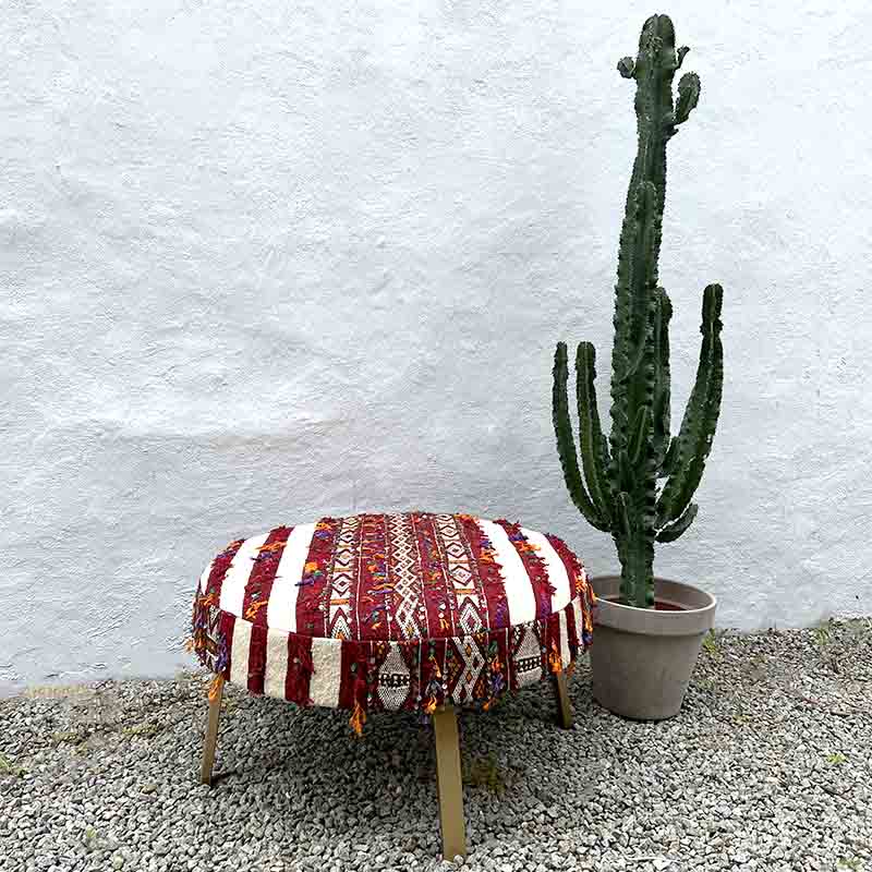 Stor håndlavet boho puf med marokkansk design ved siden af kaktus