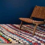 Håndvævet boucherouite tæppe i flerfarvet diagonalt stribe mønster, med loungestol ovenpå