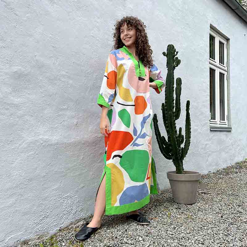 Model i marokkansk håndvævet kjole i flerfarvet frugtmønster ved siden af kaktus