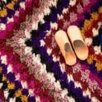 Håndvævet boucherouite tæppe i flerfarvet pile mønster, med marokkanske hjemmesko ovenpå, tæt