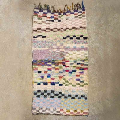 Marokkansk håndvævet Boucherouite tæppe med kvaster på den ene side i flerfarvet mønster, tæt