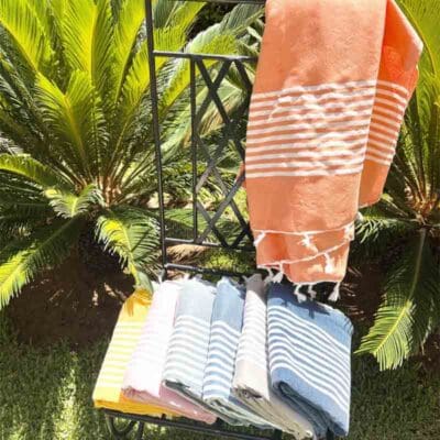 Håndvævede Fouta hammam håndklæder på en stol ved eksotiske planter
