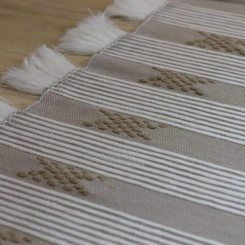 Håndvævet bomuldstæppe i beige med marokkansk stribe og prikmønster i brune nuancer med hvide kvaster, tæt