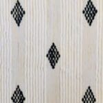 Håndvævet bomuldstæppe i hvid med marokkansk stribemønster og prikmønster i sort med hvide kvaster, tæt