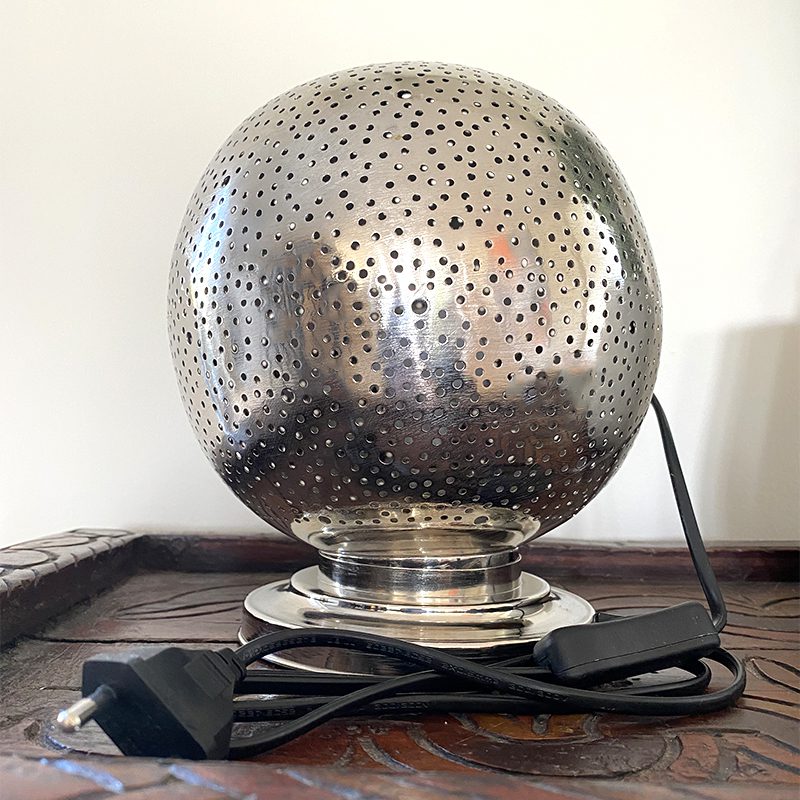 Marokkanske bordlampe i sølvmetal med enkelt hulmønster, slukket på en reol