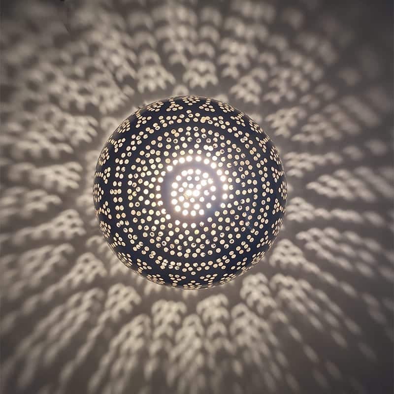 Marokkansk håndlavet bordlampe i sølvmetal med cirkelmønster, tændt i mørket