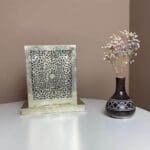Håndlavet firkantet bordlampe med marokkansk mønster, ved siden af blomstervase