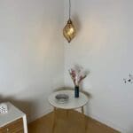 Marokkansk håndlavet snoende dråbeformet lampe hængende over et dekorationsbord