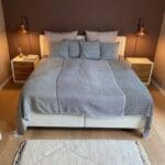Marokkansk håndvævet sengetæppe med gråt firkantet mønster på en redt seng