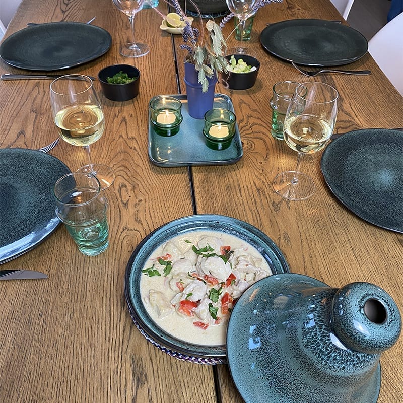 fire marokkanske tallerkener og et tagine fad i grøn marbre på et aftensmads opdækket bord