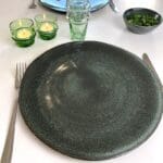 Marokkansk håndlavet tallerken i grøn marbre på opdækket bord med andet grøn service