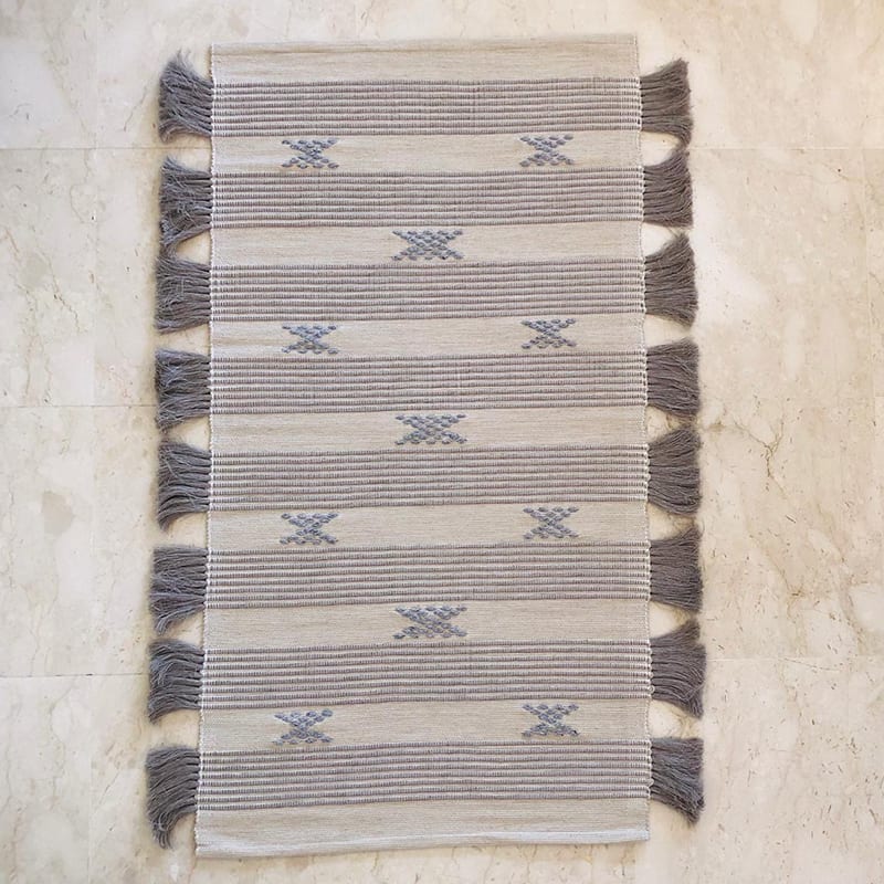 Håndvævet bomuldstæppe i hvid med marokkansk stribe og prikmønster i lyseblå med brune kvaster