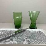 Håndlavede grønne beldi glas og vinglas stående ved siden af et fad
