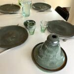 fire marokkanske tallerkener og et tagine fad i grøn marbre på et opdækket bord med beldi glas