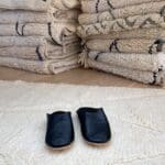 Marokkanske håndlavede slippers i sort oven på beni ouarain tæppe