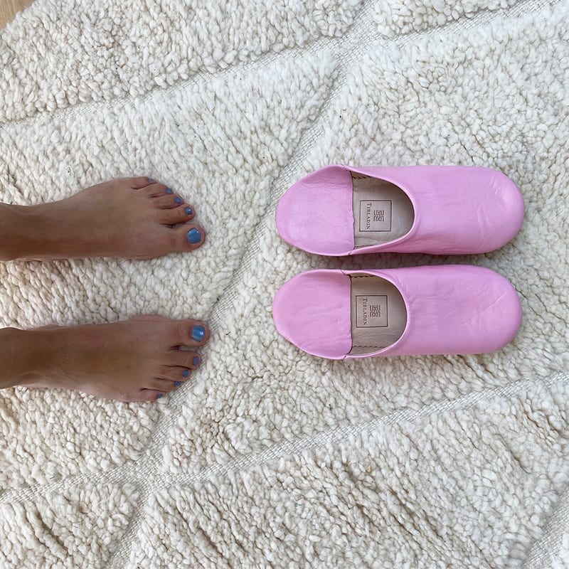 Marokkanske håndlavede slippers i rosa med fodmodel ved siden af