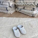 Marokkanske håndlavede slippers i hvid med mønster oven på beni ouarain tæppe
