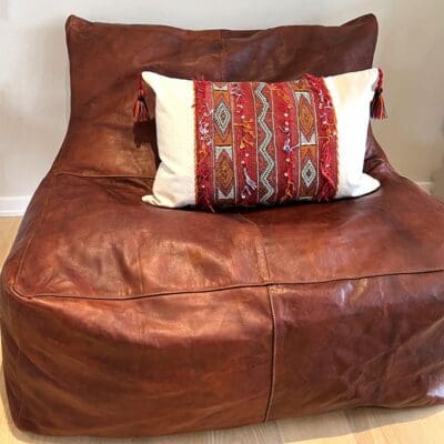 Handgeweven vintage kelim boho kussenhoes in rood en beige met Marokkaans patroon met kwastjes aan de randen van de zitzak