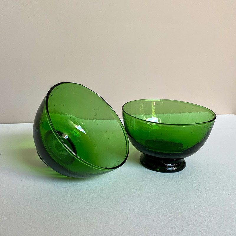 Håndlavede grønne beldi glasskåle, hvor den ene skåle står skævt