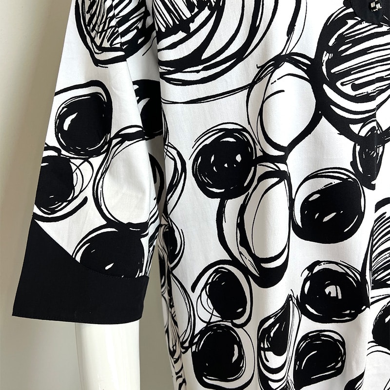 Hvid kjole med sort grafiks mønstrer med cirkler, sorte kanter
