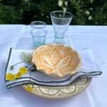Smuk marokkansk beige tallerken i en borddækning.