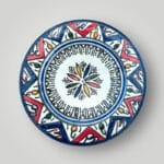 Dark blue ceramic plate with red Moroccan pattern.