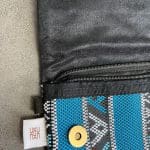 handtas van blauwe stof met patroon, ritssluiting aan de binnenkant en koperen ketting