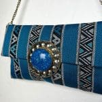 handtas van blauwe stof met patroon, ritssluiting aan de binnenkant en koperen ketting