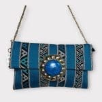 handtas van blauwe stof met patroon, ritssluiting aan de binnenkant en koperen ketting