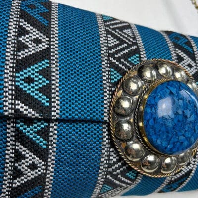 håndtaske i mønstret blåt stof med indvendig lynlås og kobber kæde