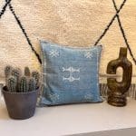 Himmelblauer Seidenkissenbezug mit Kaktusmotiv und weißem Muster.