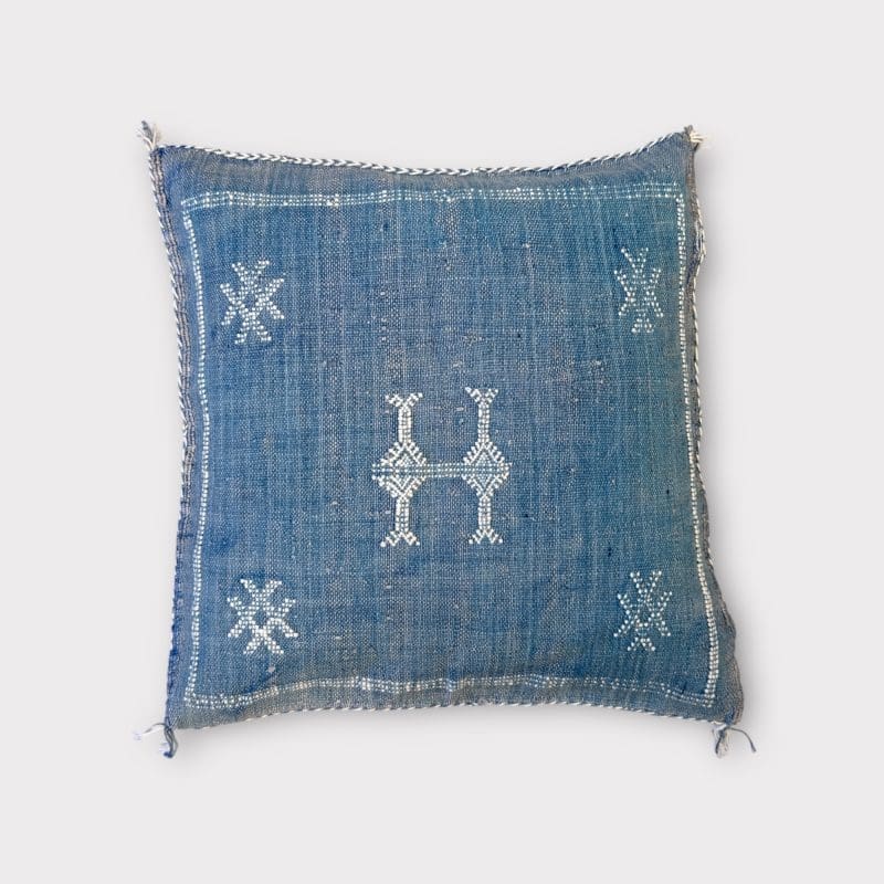 Himmelblauer Seidenkissenbezug mit Kaktusmotiv und weißem Muster.