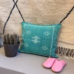 Grønt kaktus-silkeputetrekk med blålige undertoner. Turkis fargetone. Hvite sømmer/mønstre.