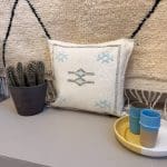 Taie d'oreiller blanche fabriquée à la main au Maroc en soie de cactus. Motifs et coutures bleues.