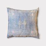 Zarter blauer Kissenbezug aus Kaktusseide mit gelben und rosa Ziernähten.