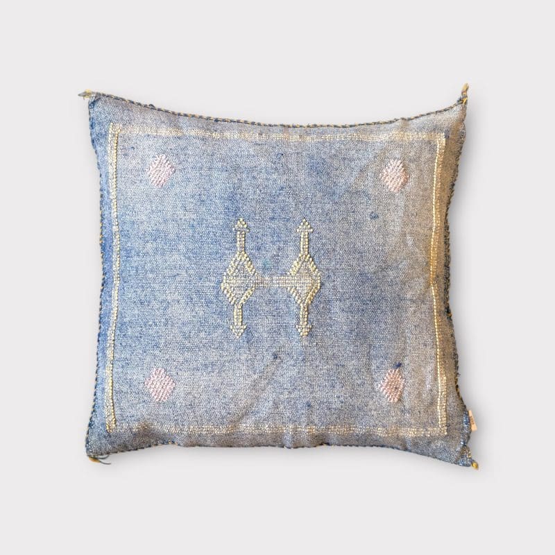 Zarter blauer Kissenbezug aus Kaktusseide mit gelben und rosa Ziernähten.