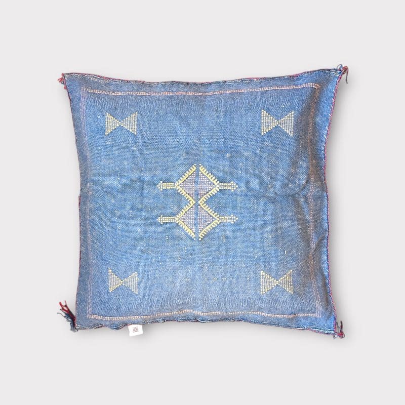 Blauer Kissenbezug aus Kaktusseide mit gelben und rosa Ziernähten.