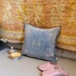 Zarter blauer Kissenbezug aus Kaktusseide mit gelben und rosa Ziernähten.